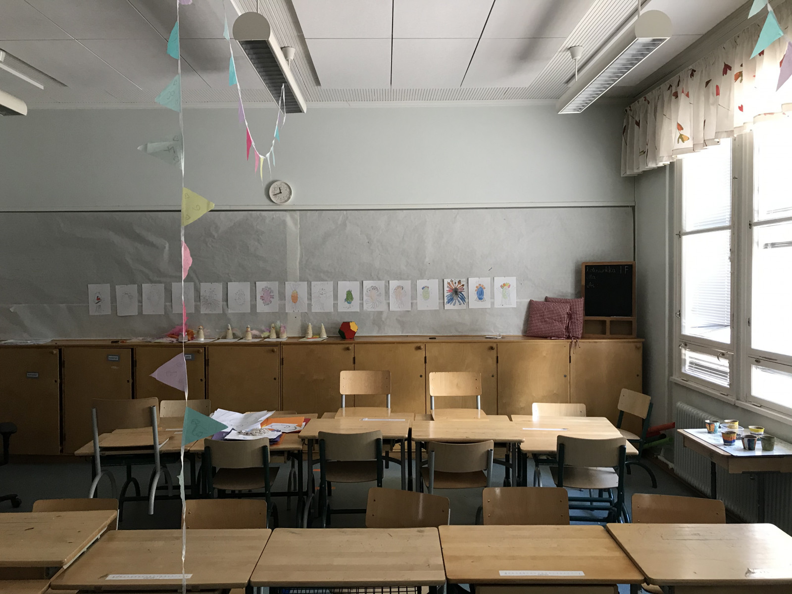 An empty classroom. There are decorations like streamers and pictures around.